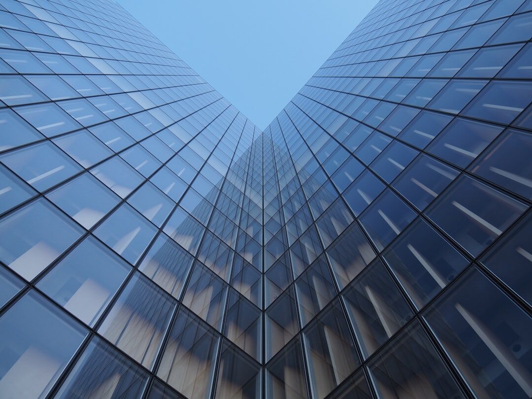 Modern glass office building exterior under a blue sky