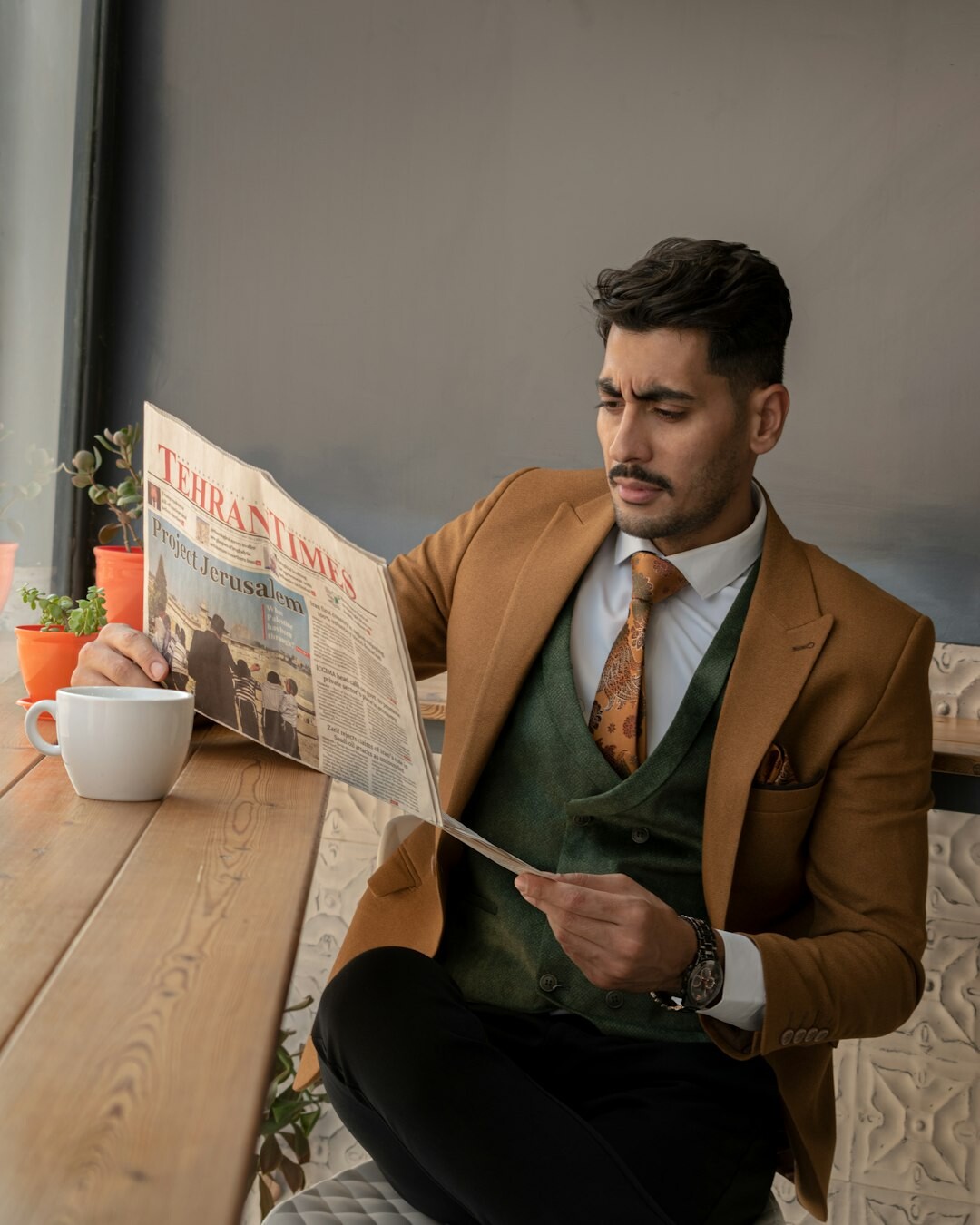 Man reading a newspaper in a cafe