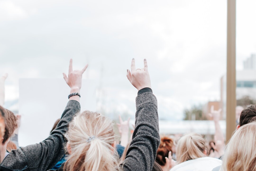 Group of colleagues celebrating with arms raised outdoors